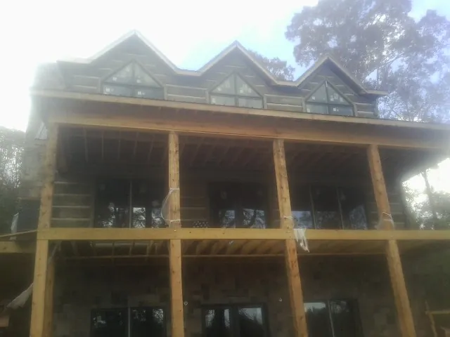 Dormers and porch framing on a large log home under construction — Roof Coating work by our crew in West Monroe